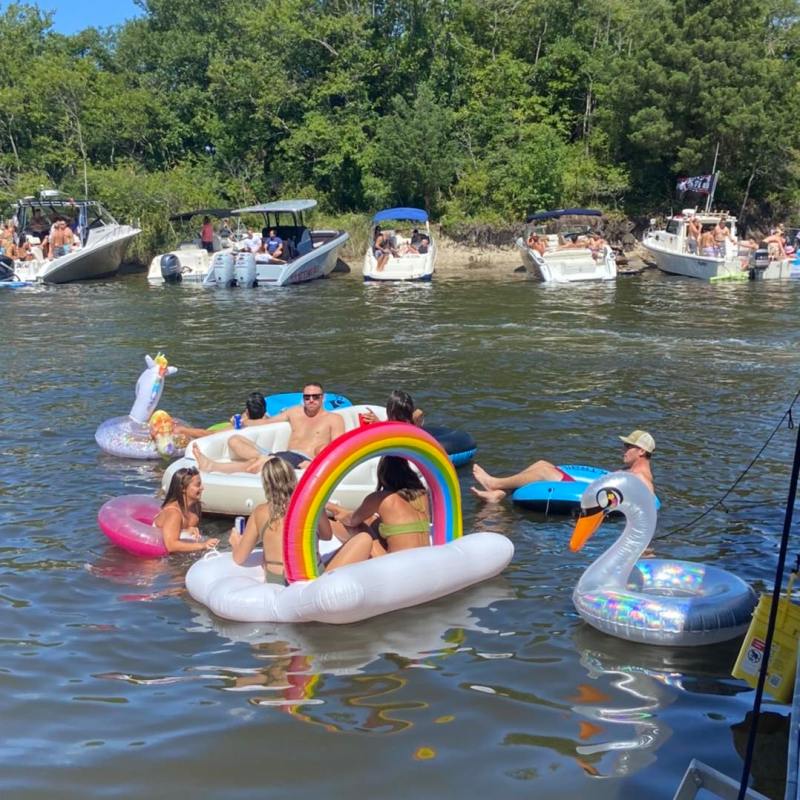 a group of people riding on the back of a boat in the water