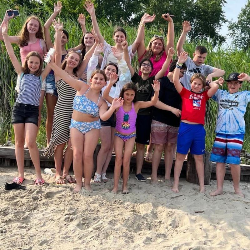 a group of people on a beach posing for the camera